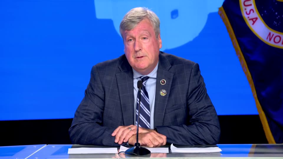 A NASA official answers questions at a televised news conference