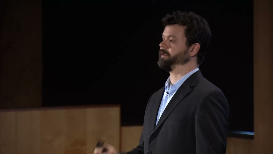A speaker on stage during a TEDx talk