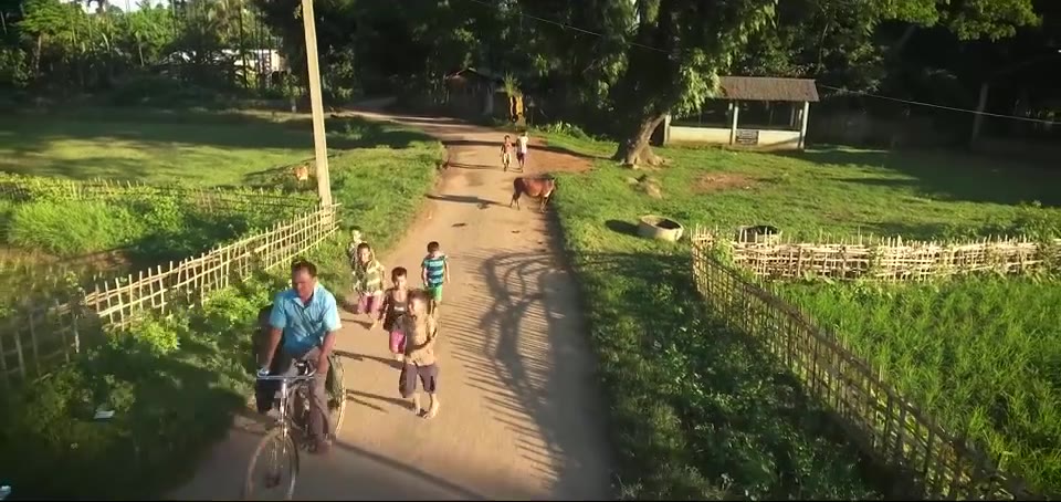 Children walking and cycling on a village path
