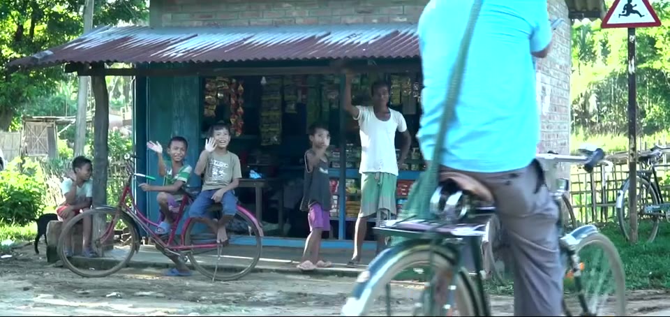Bicycle passing children at a roadside shop